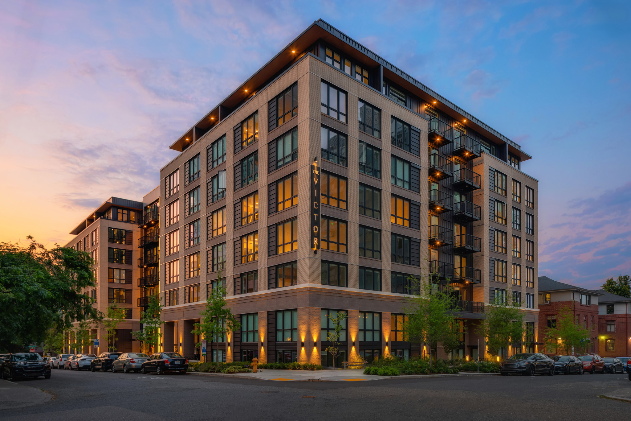 Modern apartment building exterior at twilight with large windows and balconies, located in Bellevue, Washington.