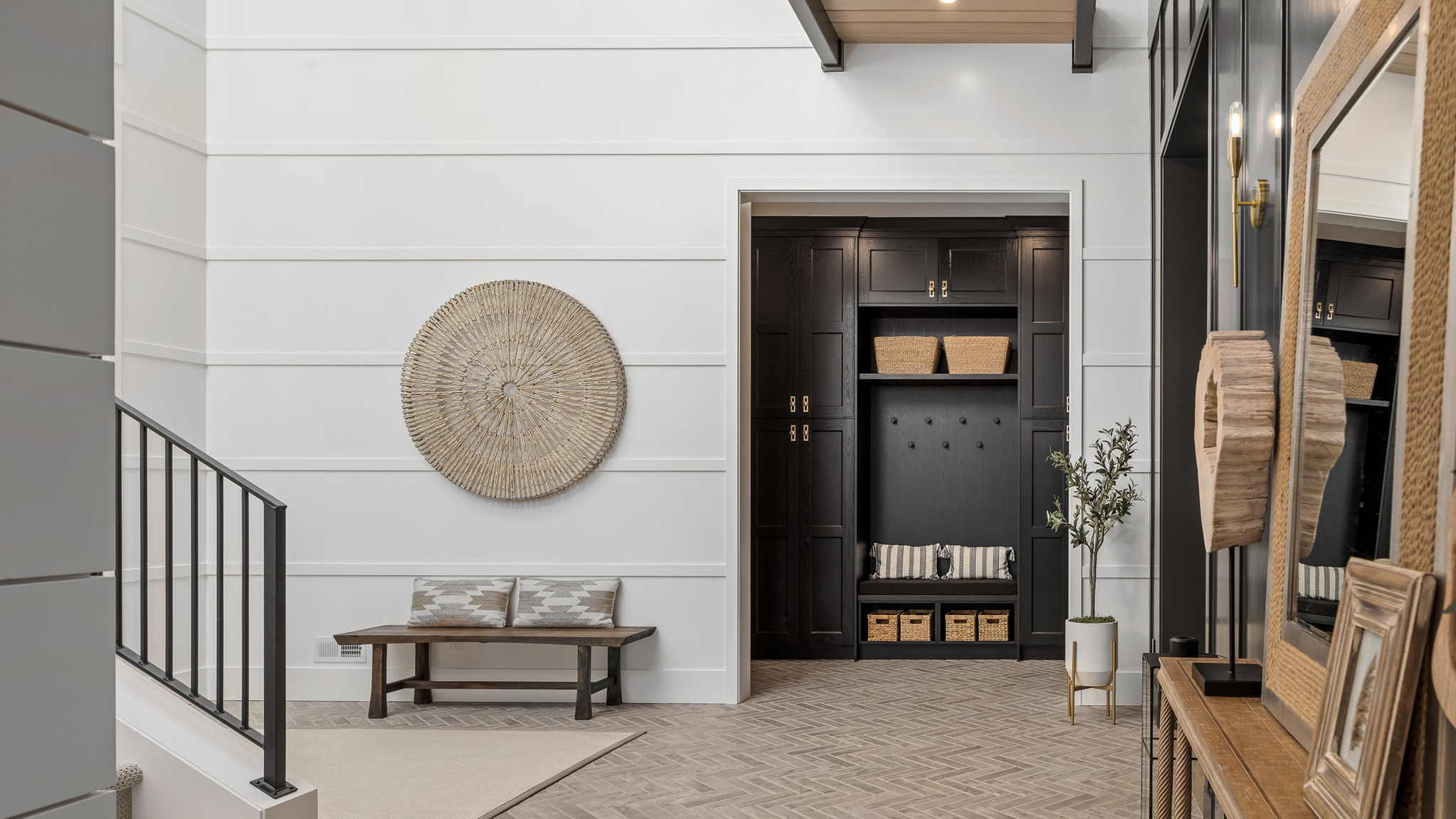Modern entryway with elegant design features, including a stylish bench, black cabinetry, and decorative wall art, located in the Pacific Northwest.