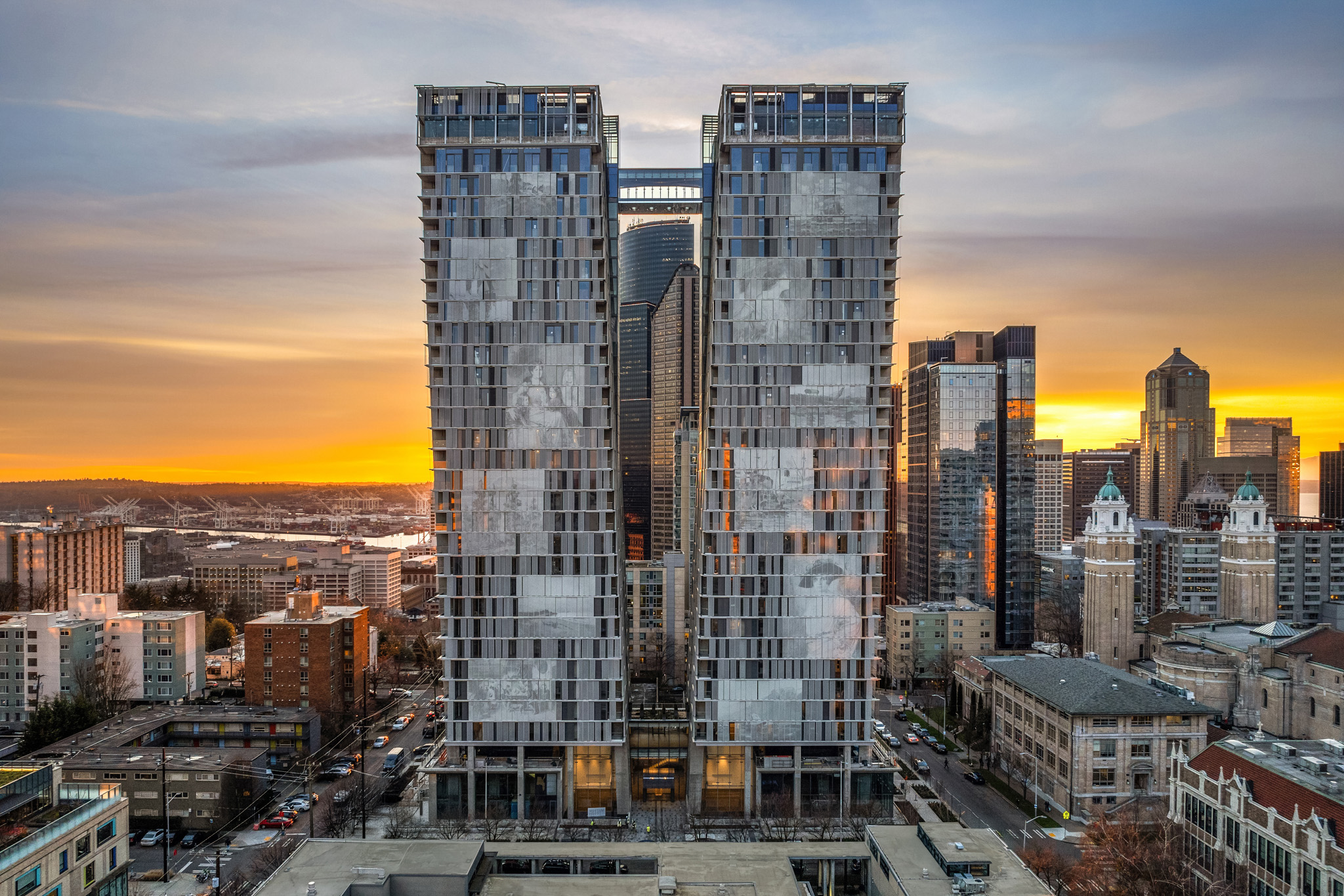 Modern high-rise buildings at sunset in downtown Seattle, showcasing sleek architectural design and urban surroundings.