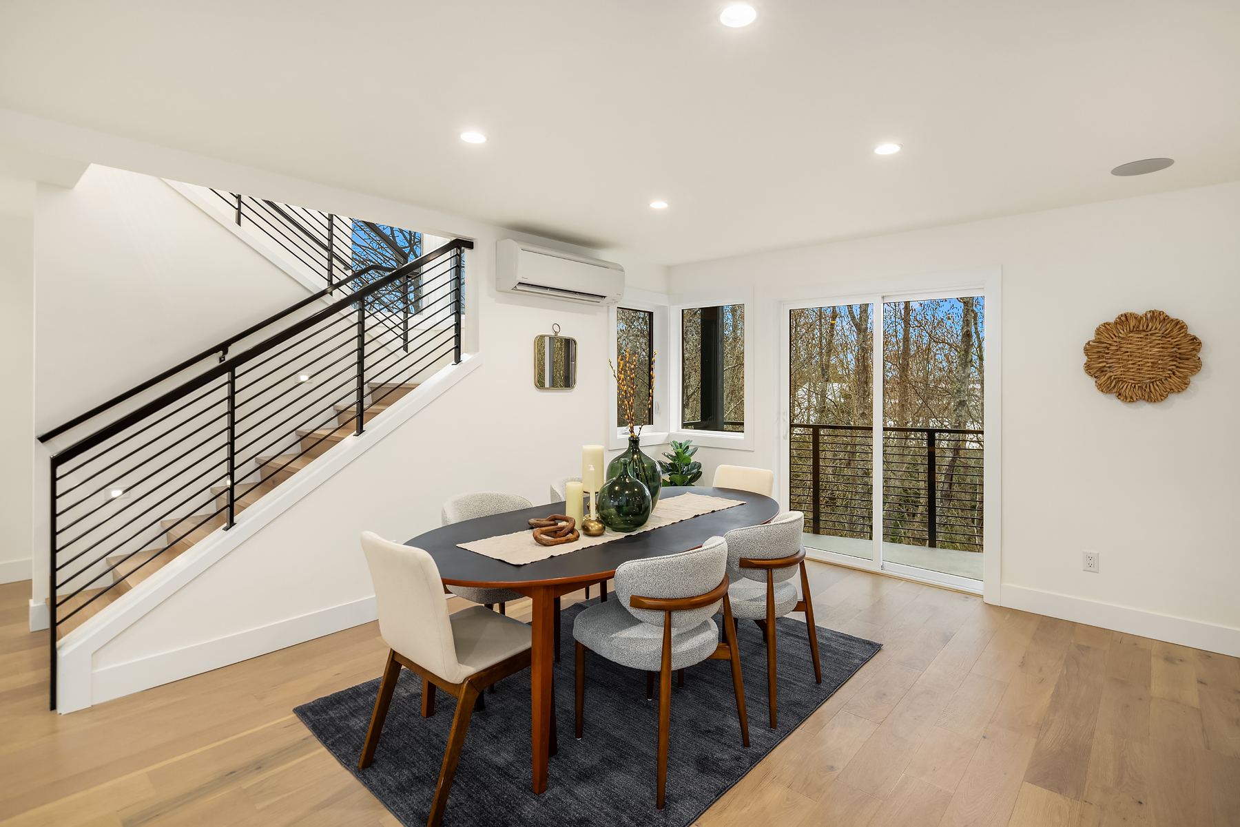 Modern dining area featuring a sleek table and stylish chairs, with large windows offering natural light and views of greenery. Located in the Pacific Northwest.